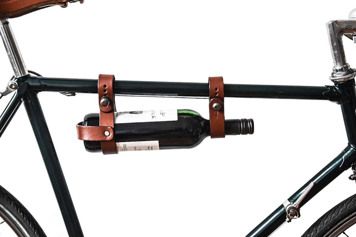 Brauner Lederflaschenhalter am Fahrradrahmen mit befestigter Weinflasche