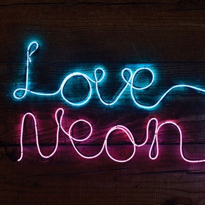 Biegsames Neonlicht zu den Schriftzügen Love und Neon geformt vor Holzwand