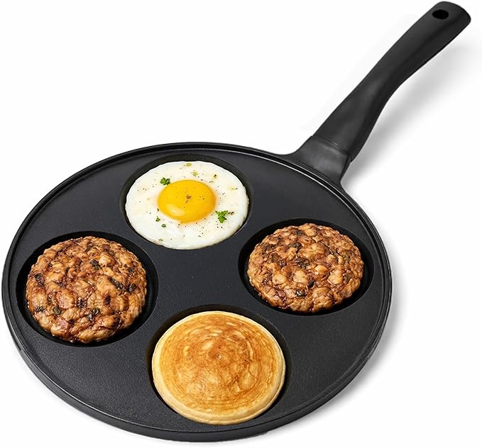 Schwarze Pfanne mit vier Mulden, gefüllt mit Spiegelei, Pancake und zwei Frikadellen